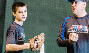 youth pitching player getting instruction for arm care and recovery