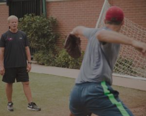 high school pitching athlete throwing with weighted baseball