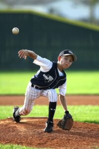 youth pitching player pitching baseball from the mound
