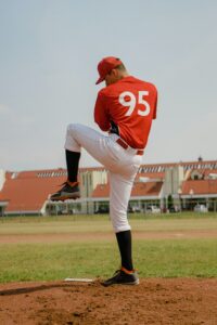 baseball pitcher with knee up using pitching velocity to strike out hitters