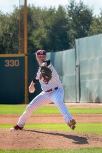 high school pitching athlete throwing from the pitching mound