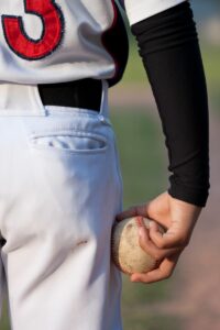 Young pitcher with correct pitch grip learned in pitching lessons from National Pitching