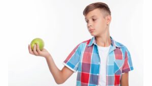 boy holding apple to eat healthy for pitching instruction