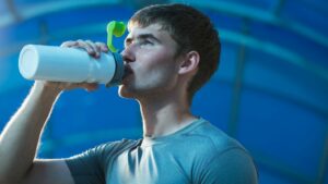 young man drinking water for youth pitching hydration